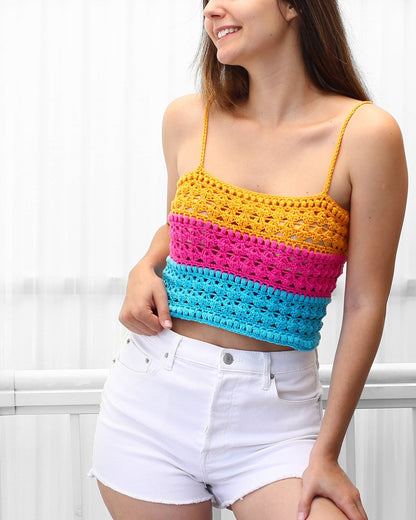 May include: A colorful crochet top with yellow, pink, and blue stripes. The top has a scoop neck and thin straps.