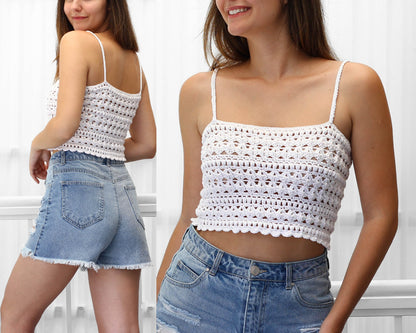 May include: White crochet crop top with a delicate openwork pattern. The top has thin straps and a square neckline.