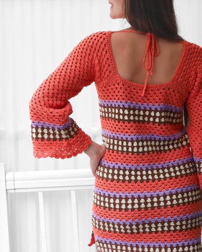 May include: A crochet dress with a square neckline and bell sleeves. The dress is made with a multi-colored striped pattern in shades of orange, brown, purple, and white.