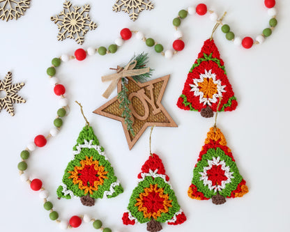 May include: Five crocheted Christmas tree ornaments in red, green, white, and orange. The ornaments are hanging from a white string with red and green beads.