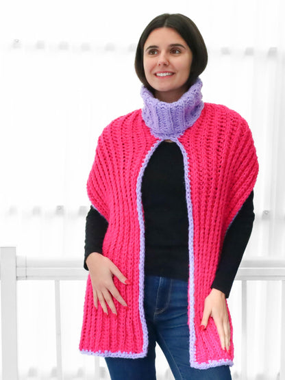 May include: A pink and purple crocheted cowl with a turtleneck. The cowl is open in the front and has a long, flowing design.
