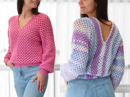 May include: Two crochet sweaters, one pink and one with blue, purple, and white stripes. Both sweaters have a V-neck and are cropped.
