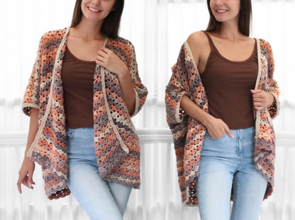 May include: A colorful, open-front crochet cardigan in shades of peach, gray, and cream. The short-sleeved garment features a geometric pattern and a cream-colored border. The cardigan is worn over a brown tank top and blue jeans.