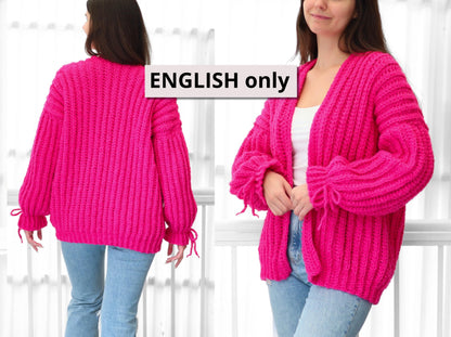 May include: A vibrant fuchsia cardigan with a chunky knit design. The open-front sweater features long sleeves with tie details at the cuffs. The model is wearing the cardigan with blue jeans.